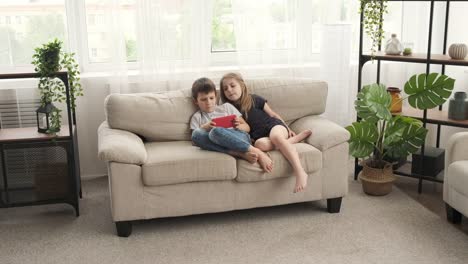 Children-lying-on-sofa-with-mobile-phone