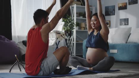 Young-man-instructing-pregnant-woman-during-workout