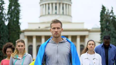 Aktivisten,-die-ukrainische-Flagge-hissen,-die-Slogan,-Unabhängigkeitskundgebung,-Patriotismus