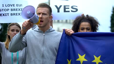 Man-with-megaphone-chanting-human-rights-slogan-waving-flag,-law-supremacy-in-EU