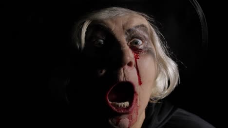 Old-witch-Halloween-makeup.-Elderly-woman-portrait-with-blood-on-her-face.