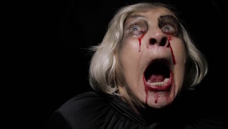 Old-witch-Halloween-makeup.-Elderly-woman-portrait-with-blood-on-her-face.