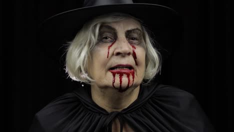 Old-witch-Halloween-makeup.-Elderly-woman-portrait-with-blood-on-her-face.