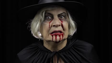 Old-witch-Halloween-makeup.-Elderly-woman-portrait-with-blood-on-her-face.