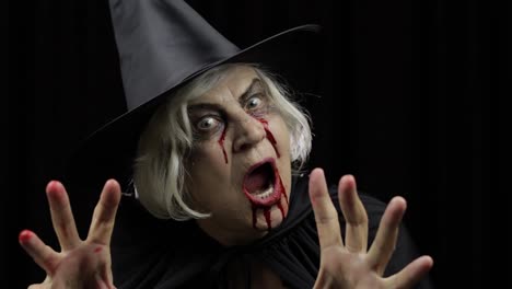 Old-witch-Halloween-makeup.-Elderly-woman-portrait-with-blood-on-her-face.
