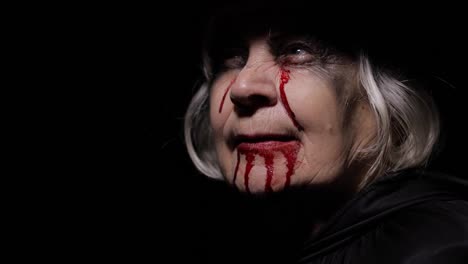 Old-witch-Halloween-makeup.-Elderly-woman-portrait-with-blood-on-her-face.