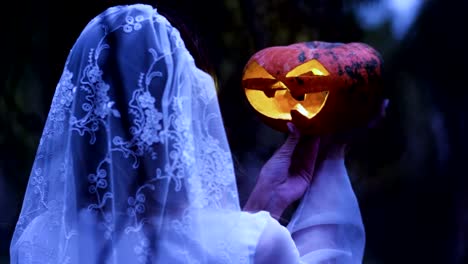 Halloween.-The-woman-holding-in-the-arms-a-pumpkin-with-a-burning-wax-candle.-4K