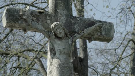 Alter-Grabstein-mit-Jesuskreuz-an-einem-sonnigen-Frühlingstag.-Schwenken-Sie-von-rechts-nach-links-auf-das-Kreuz.-4K-in-SLOG3.-Mittlerer-Schuss.