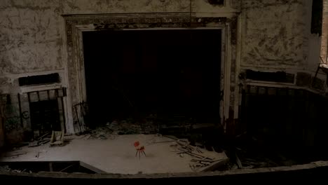 An-empty-chair-on-eerie-stage-in-abandoned-old-theatre-in-crumbling-cathedral