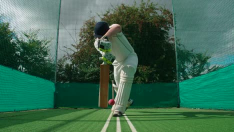 Un-jugador-haciendo-práctica-red-pega-a-la-pelota-de-cricket.