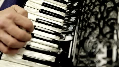 Close-up-of-a-man's-right-hand-playing-on-a-black-accordion.