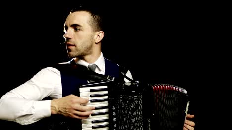 A-fashionable-musician-in-a-white-shirt-plays-the-accordion-in-the-studio-on-a-black-background.