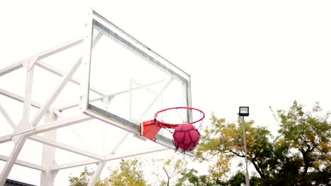 Hombre-joven-de-correr-con-la-pelota-y-lanzar-una-pelota-a-la-canasta-con-éxito.-Juego-de-baloncesto.-Tiro-de-cámara-lenta