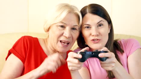 Mother-and-daughter-gamers-playing-video-game-at-home.Players-with-remote-controller-of-game-console