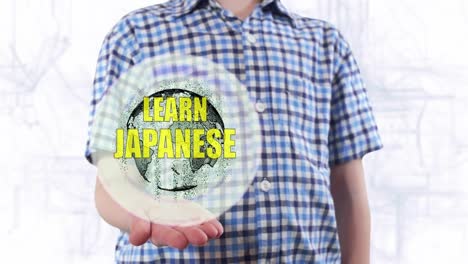 Young-man-shows-a-hologram-of-the-planet-Earth-and-text-Learn-Japanese