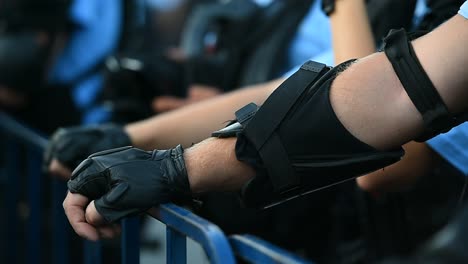 Police-officer-hands-on-a-security-fence-during-a-riot