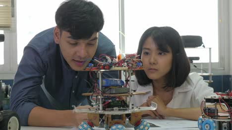 Team-of-electronics-engineer-working-together,-collaborating-on-a-project-to-build-robot.-People-with-technology-or-innovation-concept.