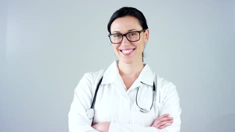 Portrait-of-a-female-doctor-with-white-coat-and-stethoscope-smiling-looking-into-camera-on-white-background.