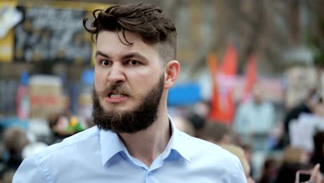 European-person-is-talking-in-megaphone-close-up.-People-scream-at-the-rally-4k.