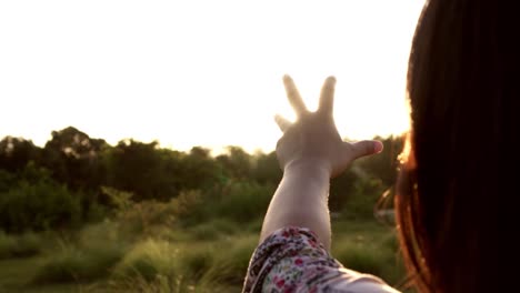 Sonnenlicht-durch-weibliche-Hände,-während-ihr-Blick-auf-Sonne