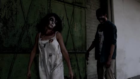 Dos-zombis-están-caminando-con-una-casa-abandonada-en-el-fondo.-Chica-morena-con-cara-herido-y-vestido-blanco-sangriento-y-zombie-hombre-herido-está-caminando-al-aire-libre