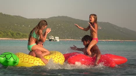 Slow-motion-view-of-fathers-and-daughters-having-a-play-fight-in-sea.