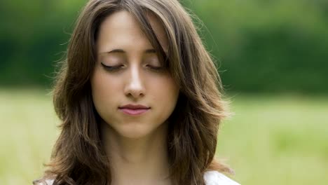 Junge-Brünette-Frau-meditiert-im-Freien,-close-up-Portrait-Frau-zutiefst-fühlt-sich