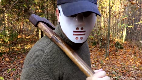 Man-in-Halloween-mask-with-an-ax-on-the-shoulder-in-close-up