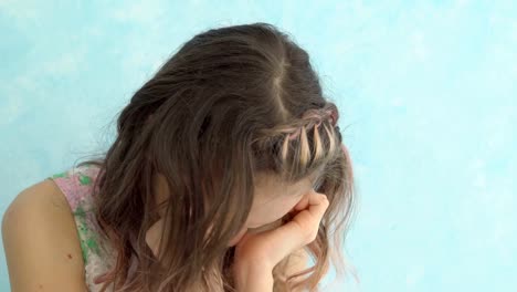 Close-up-of-a-teenage-girl-crying-at-home,-covering-her-face-with-hands