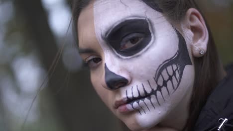 Halloween.-Mädchen-mit-einem-beängstigend-Make-up-auf-dem-Boden-des-Gesichts