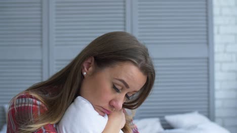 Upset-lonely-woman-hugging-pillow-in-problems