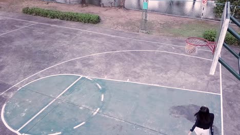 lenta-del-baloncesto-de-práctica-de-niña-en-el-patio-después-de-la-escuela