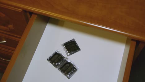 A-man-takes-a-condom-from-the-bedside-table.-Protection-against-aids-and-pregnancy.