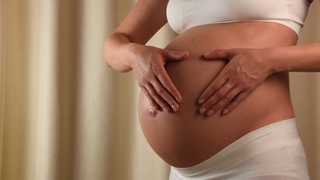 Pregnant-woman-touching-her-belly-with-hands