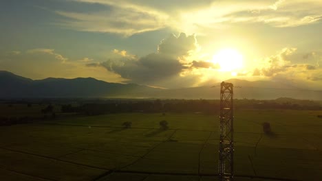 Fliegen-nach-der-hohen-Spannung-Strom-Turm-mit-Sonnenuntergang