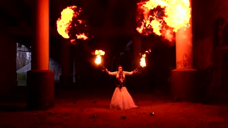 A-couple-in-wedding-dresses-and-with-skull-makeup-perform-a-fire-show.-Halloween