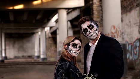 Halloween-loving-couple-in-costumes-of-skeletons-and-sugar-skull-make-up.