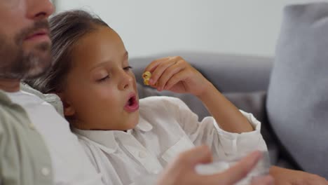 Schöne-Mädchen-essen-Popcorn-und-vor-dem-Fernseher-mit-Papa