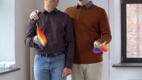 pareja-masculina-con-banderas-de-arco-iris-del-orgullo-gay-en-casa