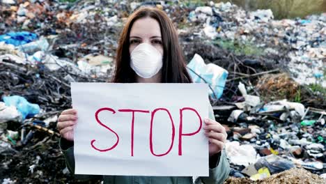 Frau-Aktivist-mit-Stop-Poster-auf-Deponie