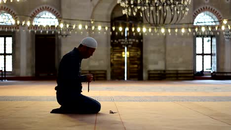 Young-adult-caucasian-man-at-the-mosque,-worship-with-prayer-beads-or-rosary