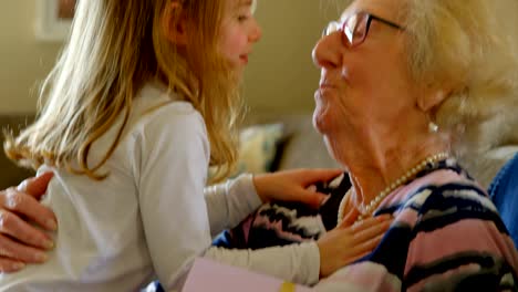 Grandmother-and-granddaughter-kissing-each-other-in-living-room-4k