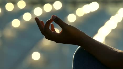 Woman-sitting-in-yoga-position,-female-hand-close-up,-meditation-and-relaxation