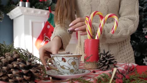 Girl-puts-a-cup-on-the-New-Year's-table