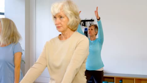 Entrenador-de-asistencia-a-senior-femenino-en-la-realización-de-yoga-4k