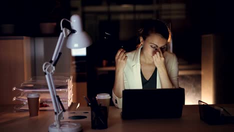 Schöne-Mädchen-in-formelle-Kleidung-bei-der-Arbeit-am-Laptop-allein-im-dunklen-Büro-spät-in-die-Nacht-beenden,-dringende-Arbeitsüberlastung.-Moderne-Technologie-und-Job-Konzept.