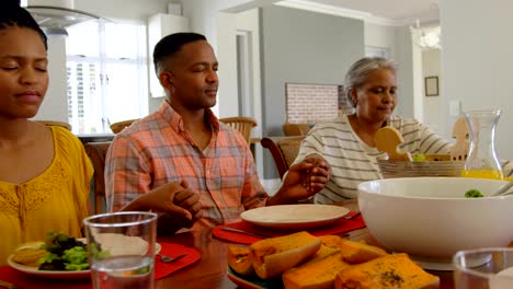 Front-view-of-black-family-praying-together-at-dining-table-in-comfortable-home-4k