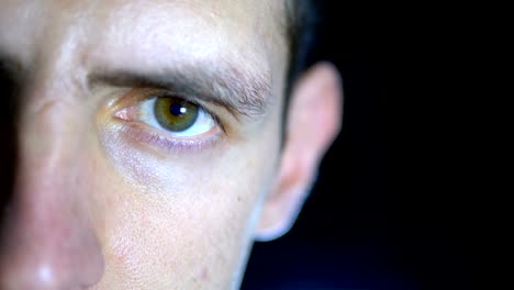 Mirada-seria-de-un-hombre-joven-que-concentró-trabajos-sobre-un-fondo-negro.-Cámara-lenta