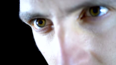 Close-up-of-the-eyes-and-face-of-a-young-man-working-at-a-computer-on-a-Black-Background