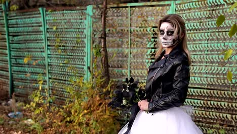 Creepy-bride-with-a-bouquet-of-black-flowers-and-make-up-in-the-form-of-a-skull